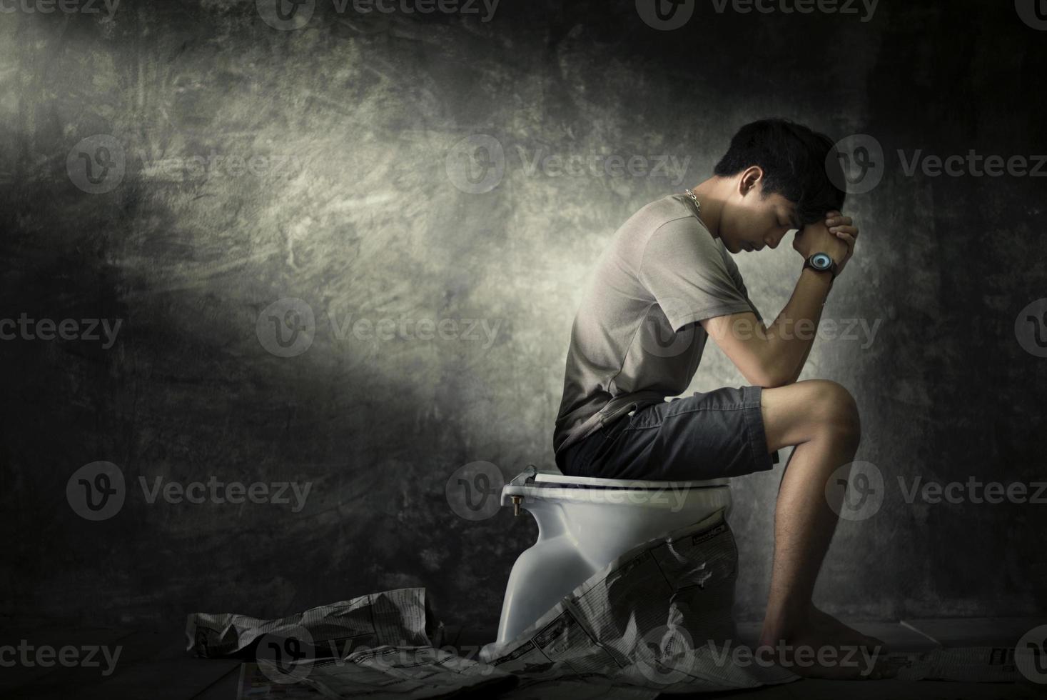 um homem senta-se em um canto escuro contemplando e preocupado. conceito de depressão foto