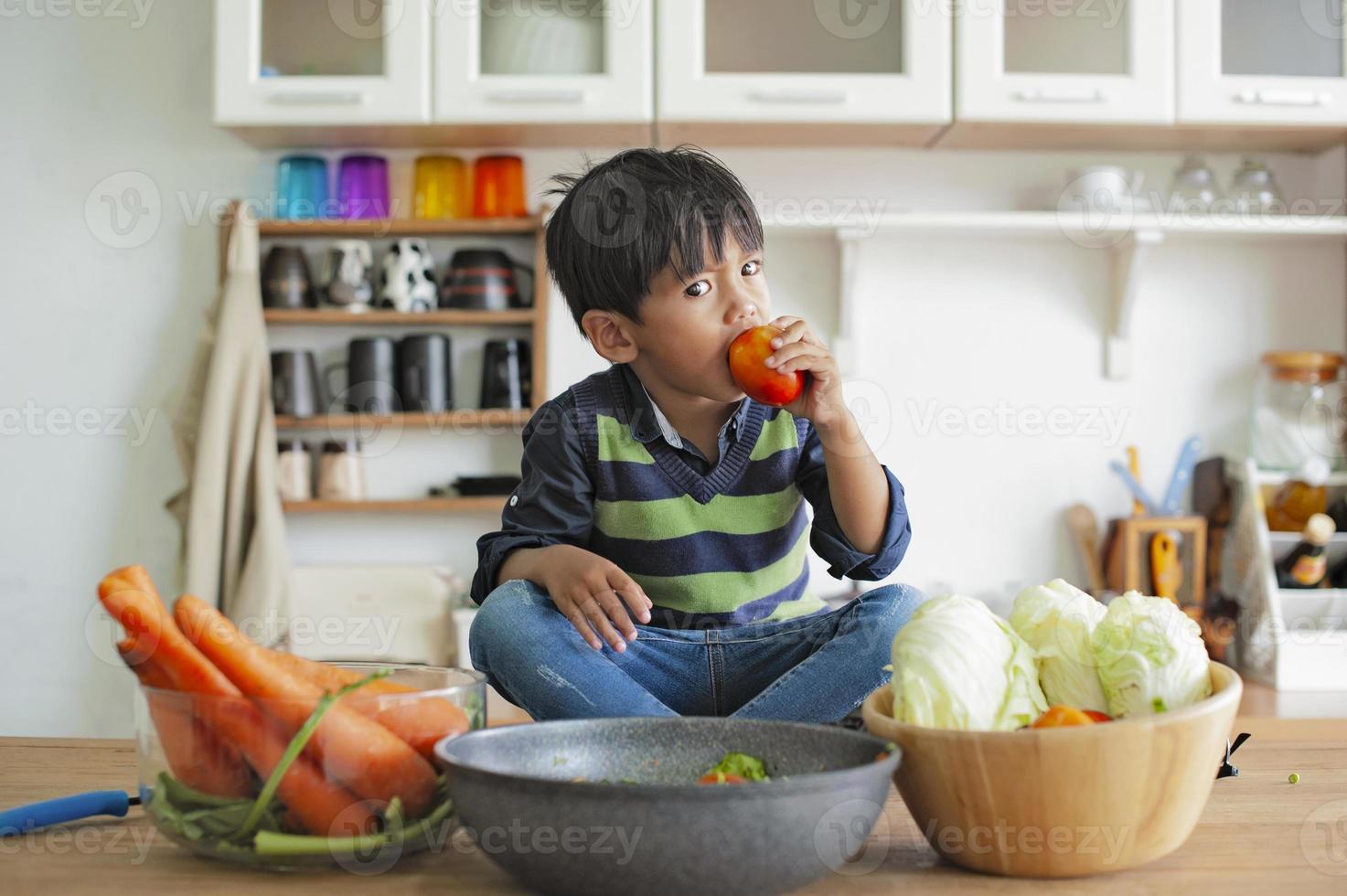 um menino comendo com um olhar sério. conceito emocional foto