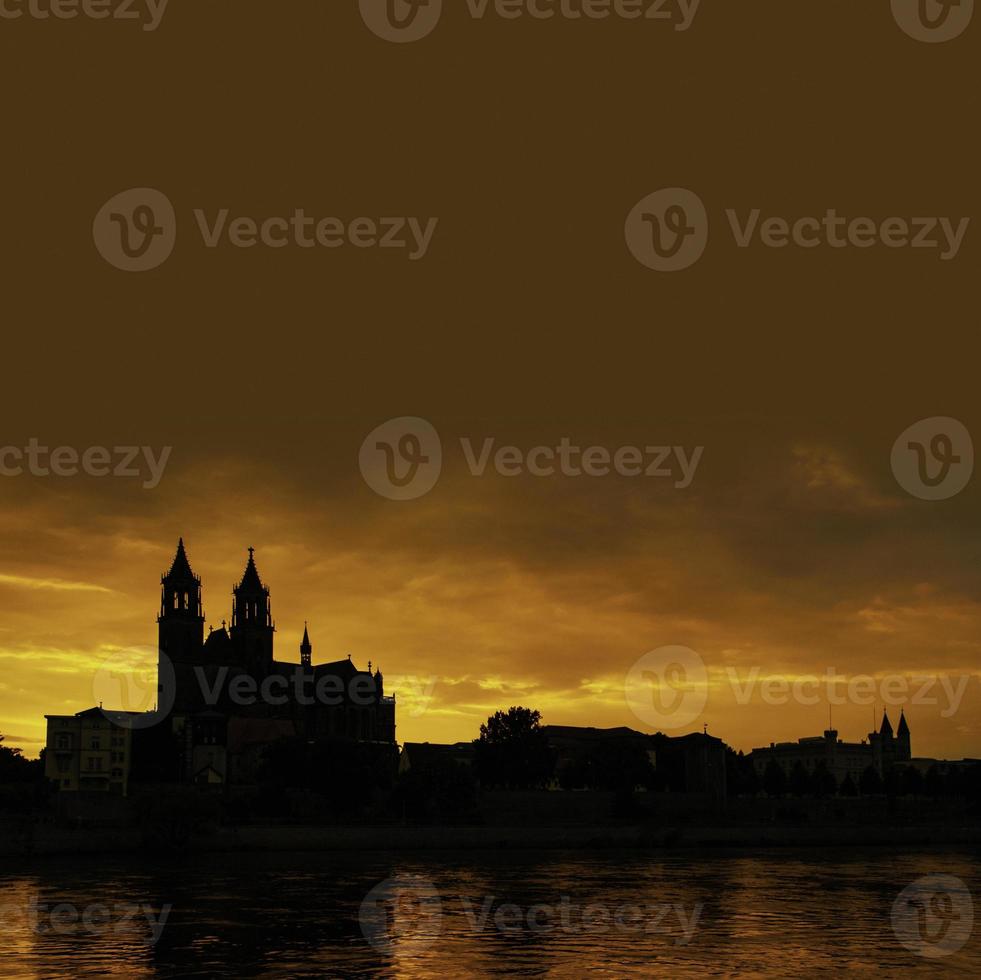 silhueta de um castelo medieval no belo pôr do sol sangrento no centro histórico de magdeburg, cidade velha, rio elba e magnífica catedral, alemanha. foto