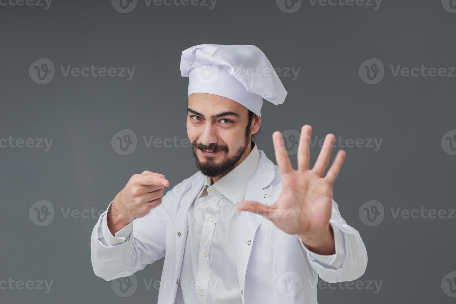 espantado jovem chef italiano masculino bonito, ele está gesticulando sinal de cinco, tiro do estúdio inclui espaço de cópia. foto