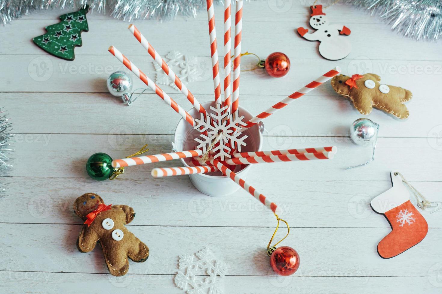 bastões de doces de natal em pote com decoração na mesa foto