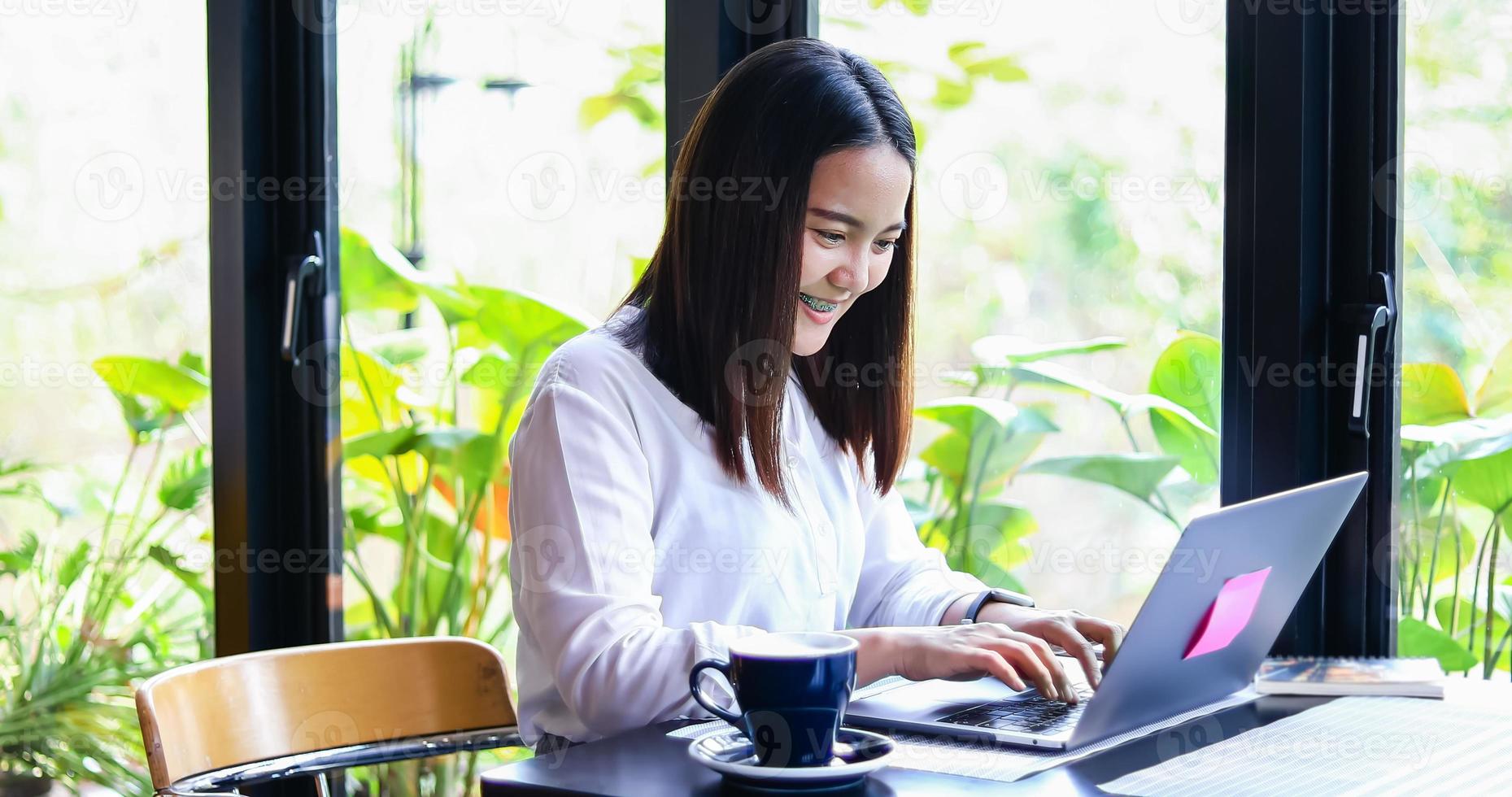 lindas mulheres de negócios asiáticos verificando documentos e usando notebook trabalhando em casa para distância social e conceito de auto-responsabilidade foto