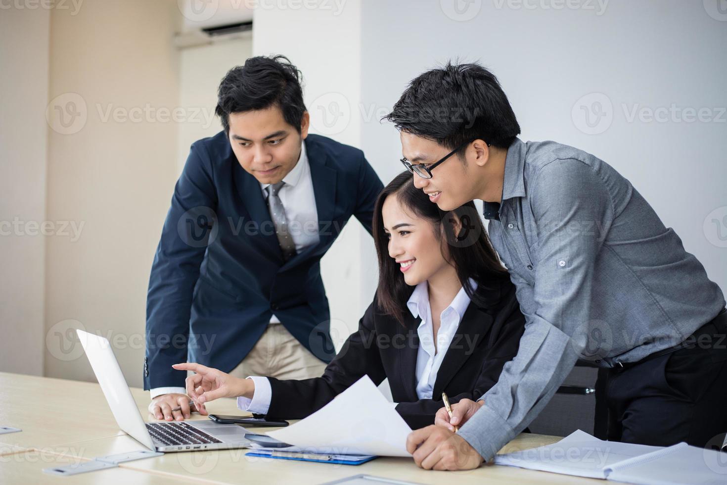 Empresários asiáticos e grupo usando notebook para parceiros de negócios discutindo documentos e ideias em reuniões e mulheres de negócios sorrindo felizes por trabalhar foto