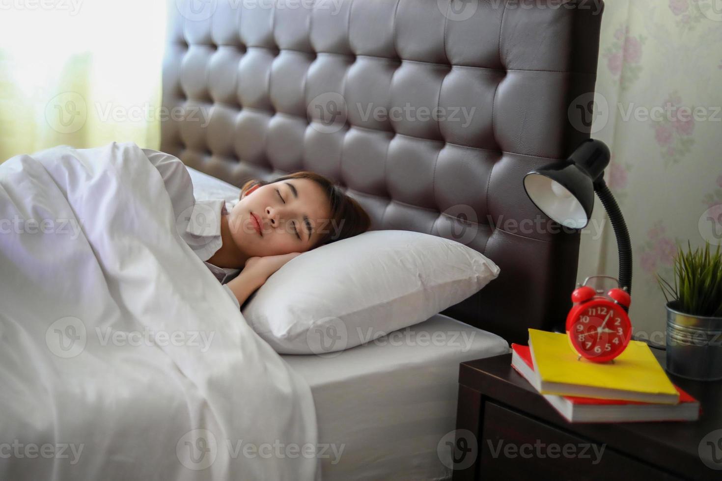 linda mulher asiática dormindo na cama branca. foto