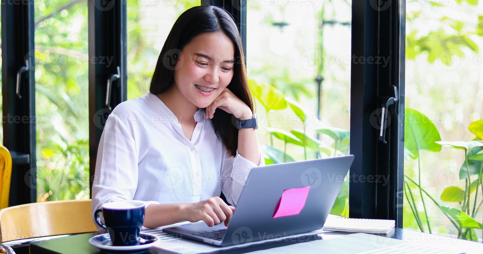 lindas mulheres de negócios asiáticos verificando documentos e usando notebook trabalhando em casa para distância social e conceito de auto-responsabilidade foto