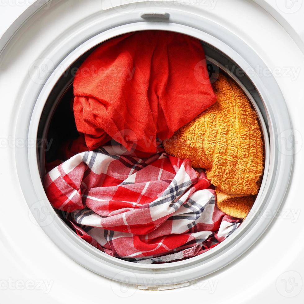 máquina de lavar ou lavadora cheia de laváveis coloridas foto