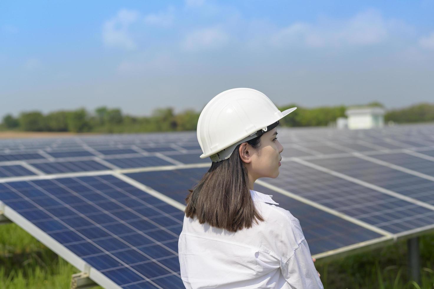 engenheira usando capacete em fazenda de células fotovoltaicas ou campo de painéis solares, energia ecológica e limpa. foto