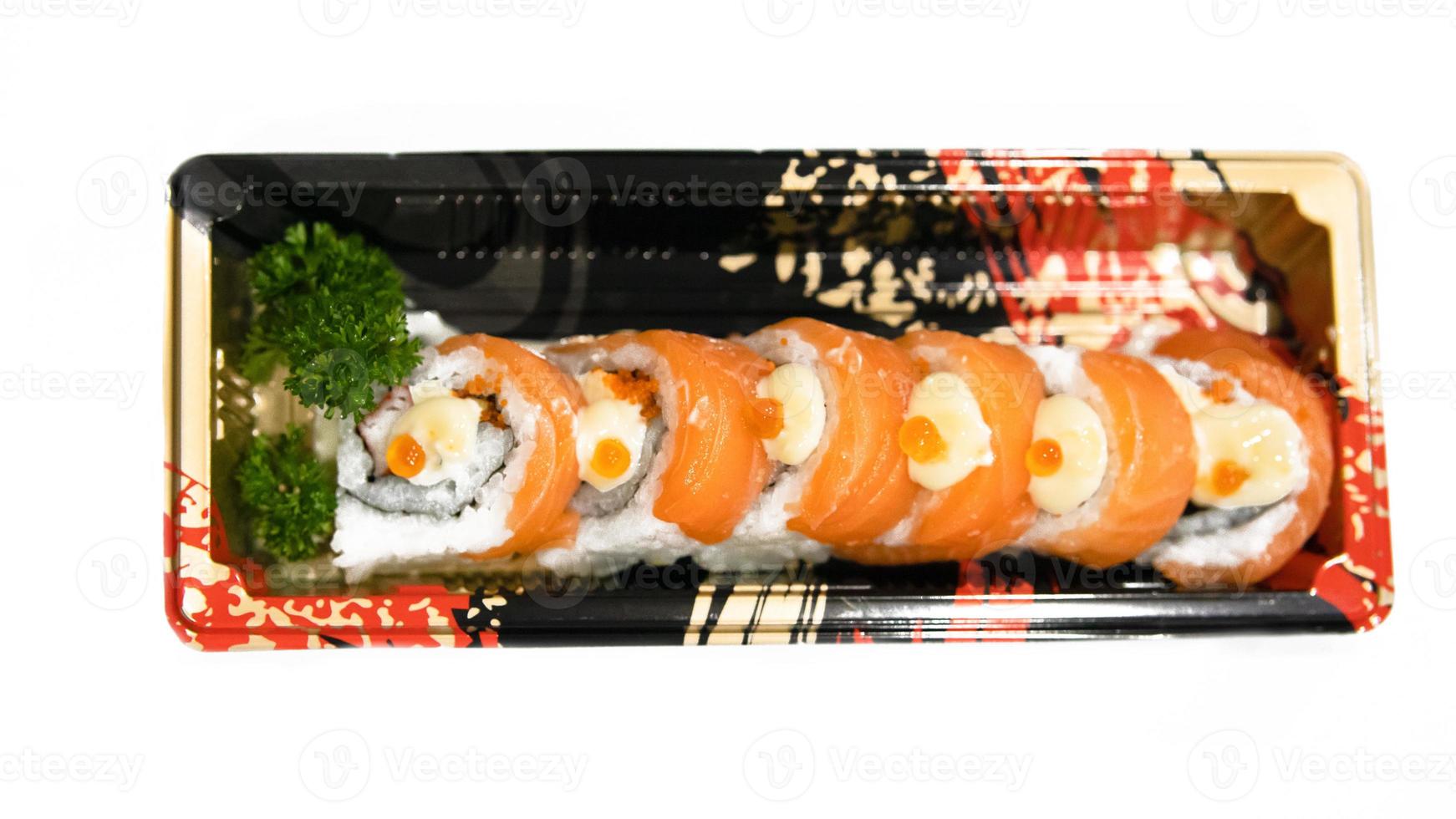 rolo de sushi de salmão com molho picante em fundo branco. foto