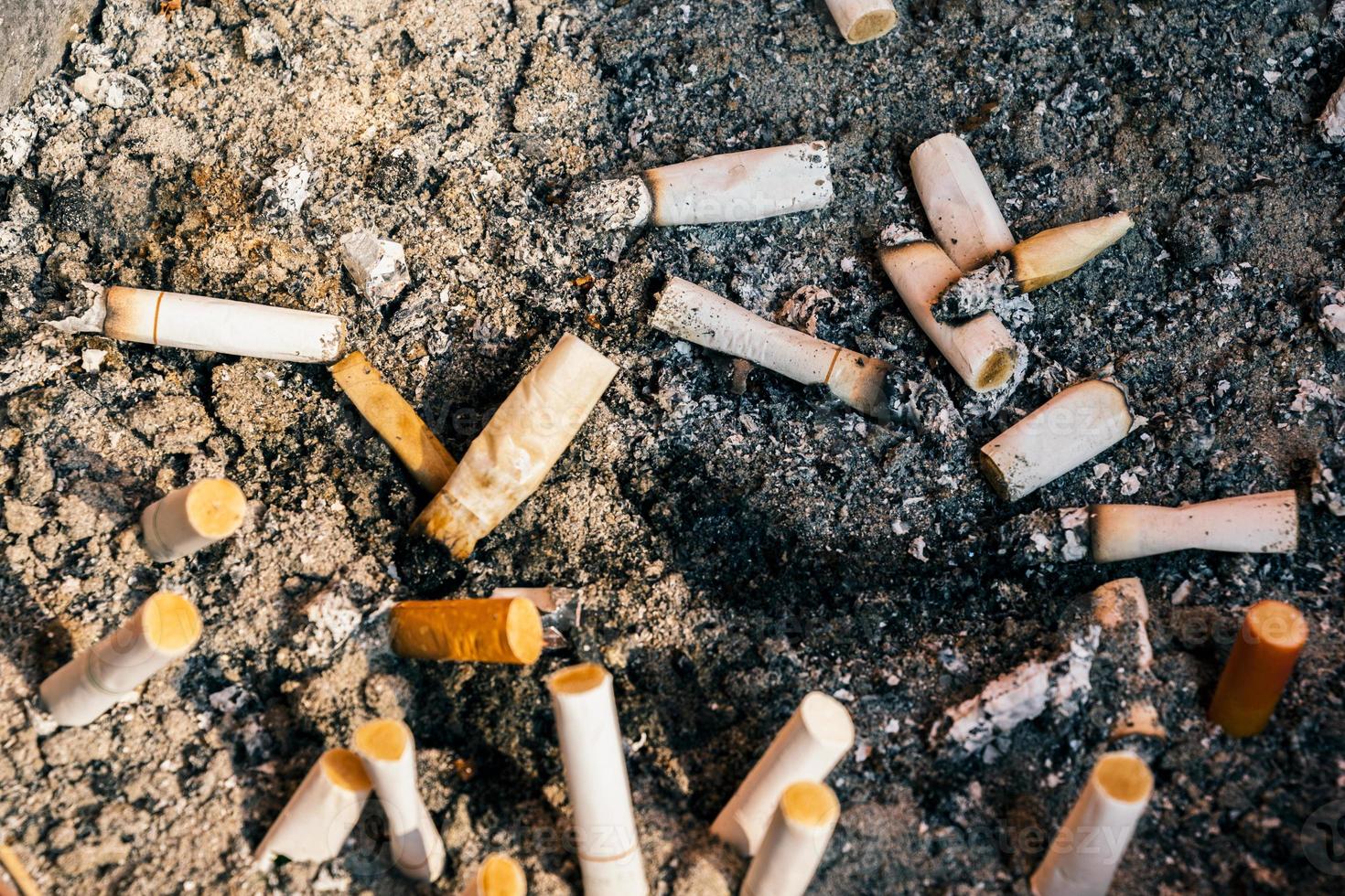 close-up das pontas de cigarro que foram fumadas no cinzeiro. foto