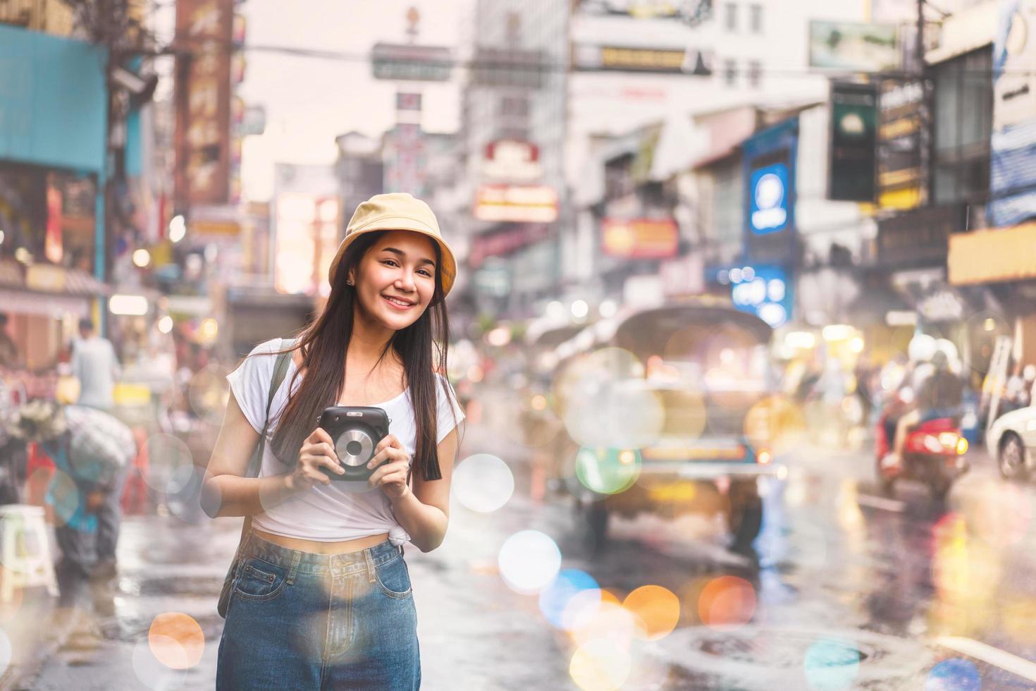 mulher asiática viajante com câmera em chinatown. foto