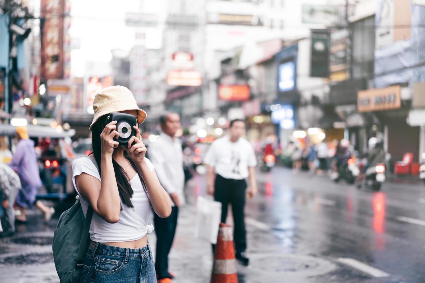 mulher asiática de estilo vintage com câmera instantânea em bangkok, tailândia foto