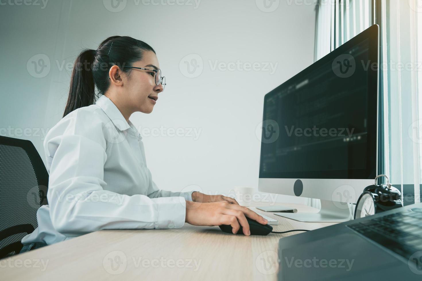 mulheres desenvolvedoras de software asiáticas estão analisando juntas sobre o código escrito no programa no computador na sala de escritório. foto