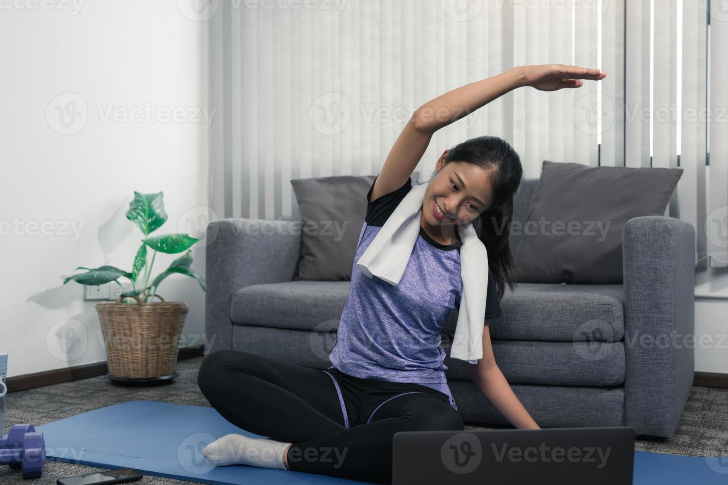 jovem mulher asiática alongamento após o treino em casa. foto