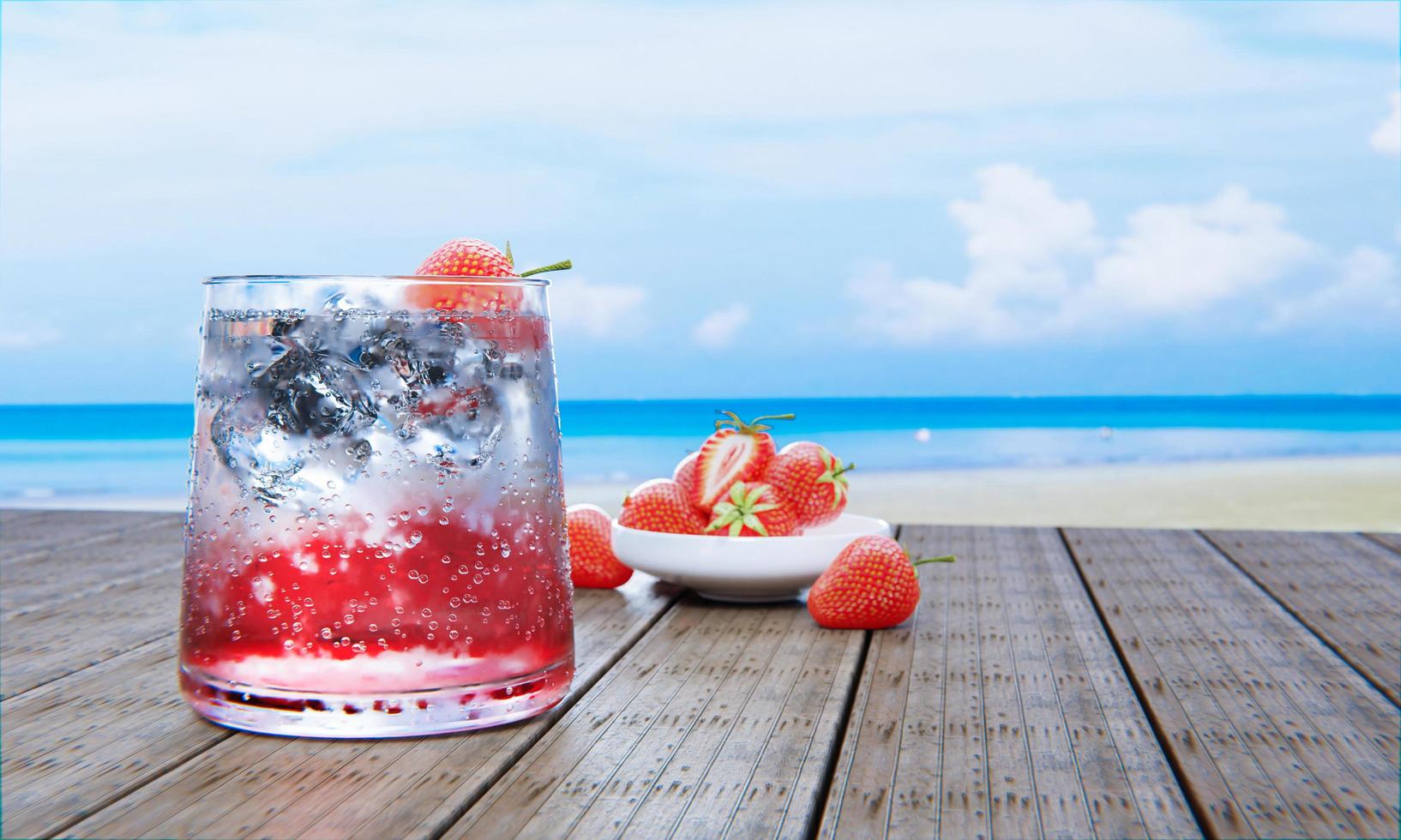 refrigerante de morango mocktail não misture álcool. morangos frescos em tigela de cerâmica no desfoque de fundo na mesa de madeira de prancha. restaurante na praia e mar. bebidas frescas de suco com cubos de gelo. renderização 3D. foto