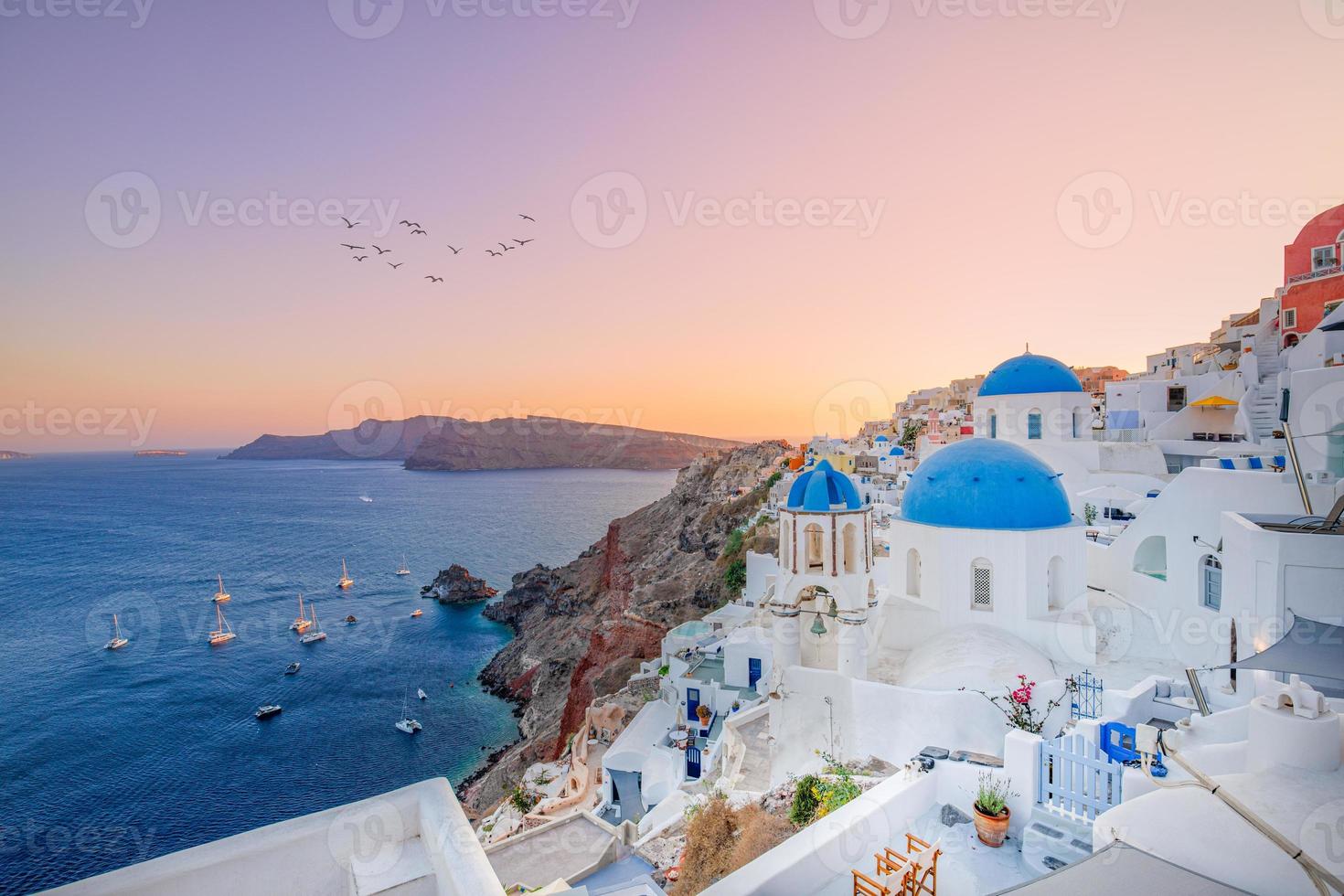 visão noturna do pôr do sol da tradicional vila grega oia na ilha de santorini, na grécia. santorini é um destino de viagem icônico na grécia, famoso por seus pores do sol e arquitetura branca tradicional foto