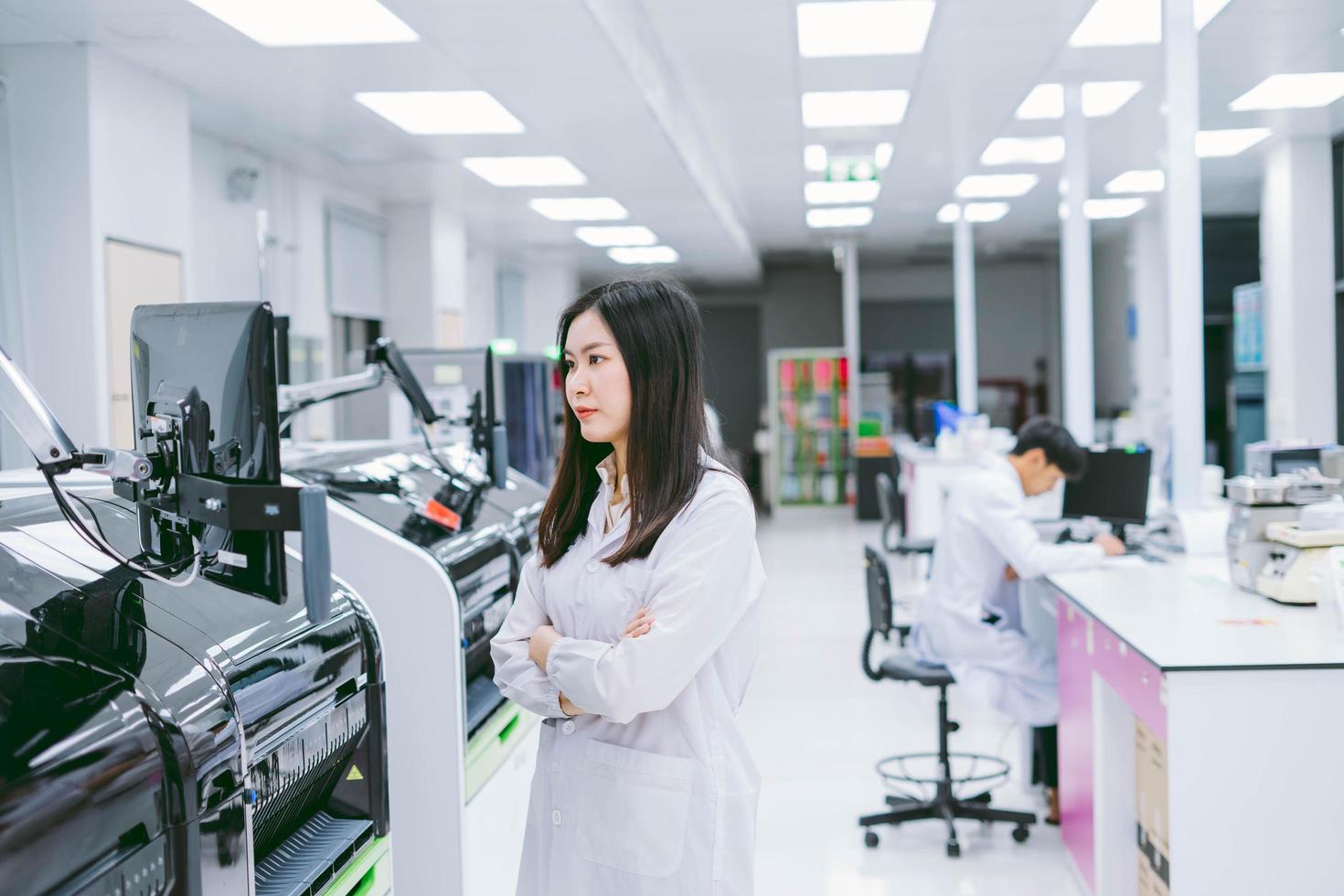 jovem cientista trabalhando com relatório de analisador de sangue de automação em laboratório médico foto