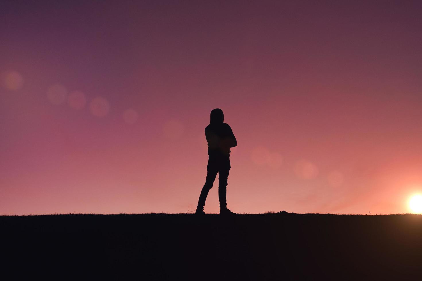 silhueta de homem trekking na montanha com um belo pôr do sol foto