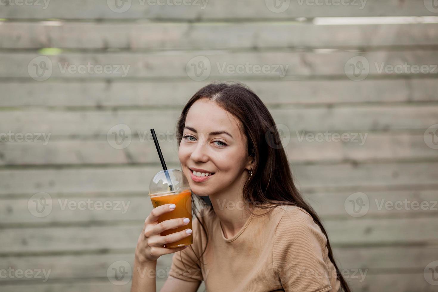 mulher segurando uma xícara de smoothie para viagem foto