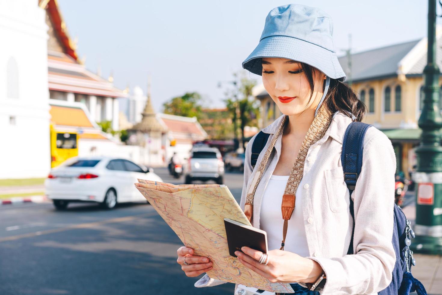 atraente jovem hipster adulto viajante mulher asiática usando mapa para viagens foto