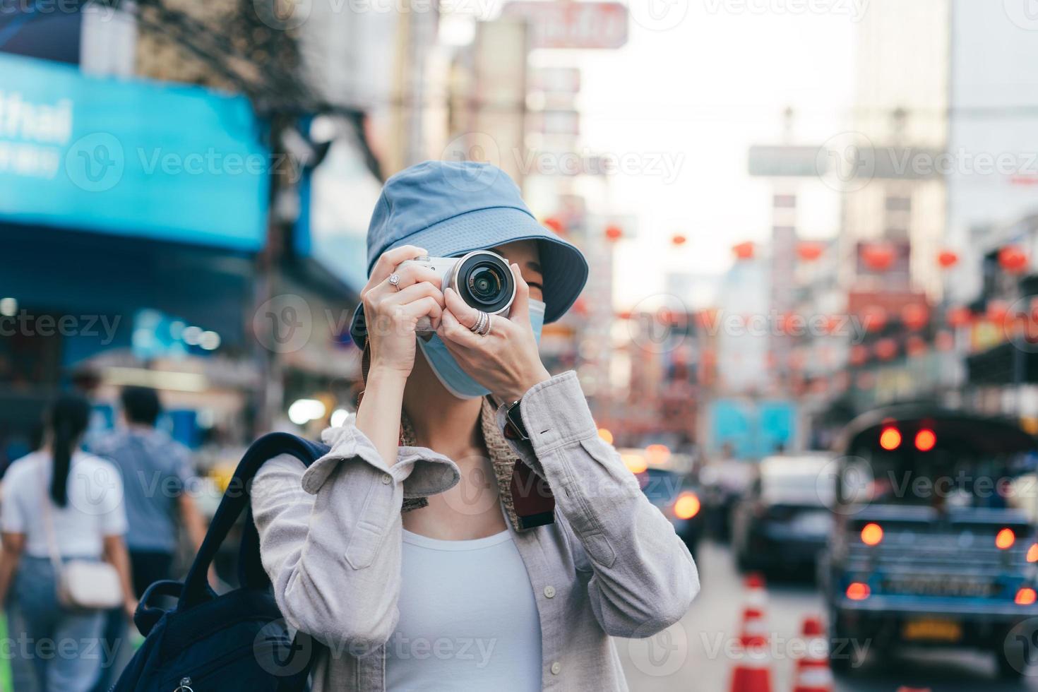 jovem adulto mulher asiática viajante feminino usando a câmera. foto