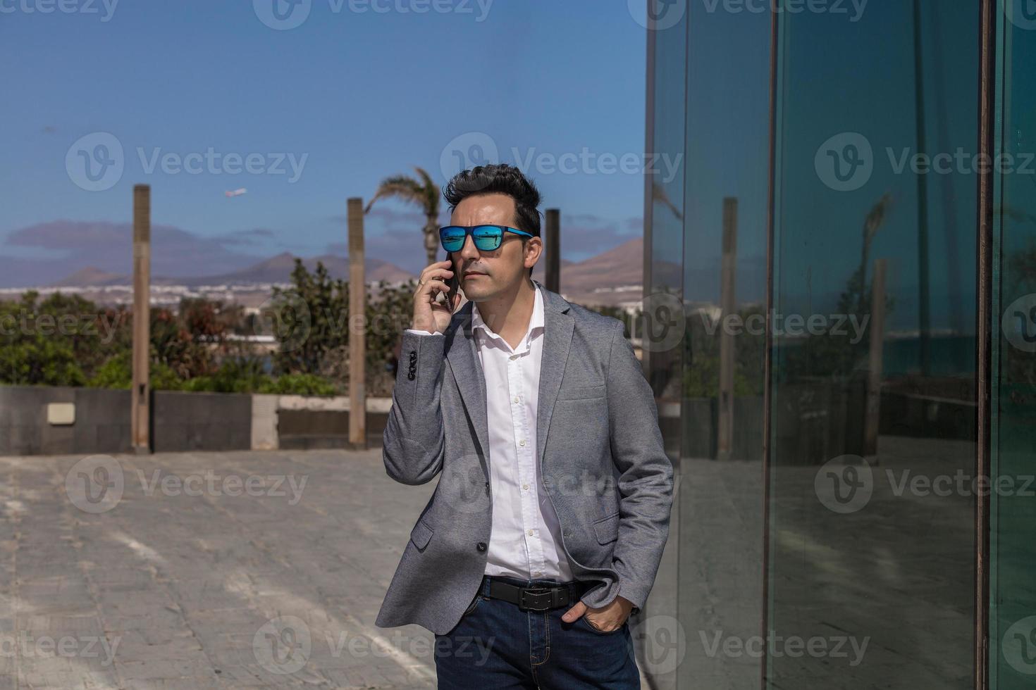 empresário masculino atendendo telefonema na rua foto