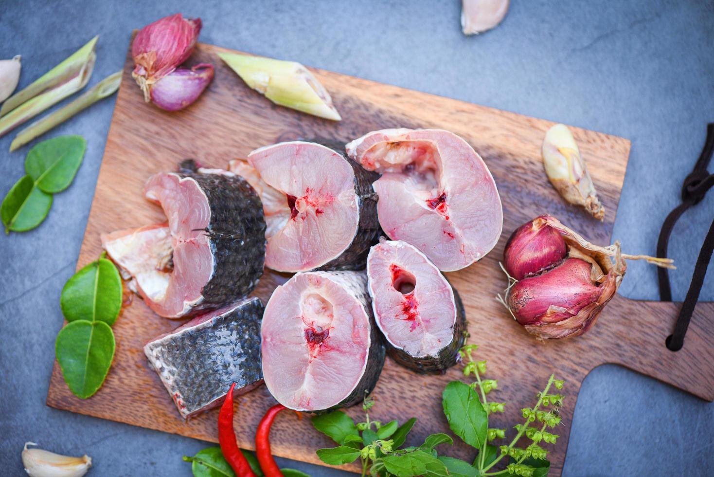 peixe cabeça de cobra listrado picado com ingredientes ervas e especiarias na tábua de madeira e fundo de cozinha de mesa, menu de peixe cabeça de cobra cru fresco peixe de água doce, peixe cabeça de cobra para cozinhar alimentos foto