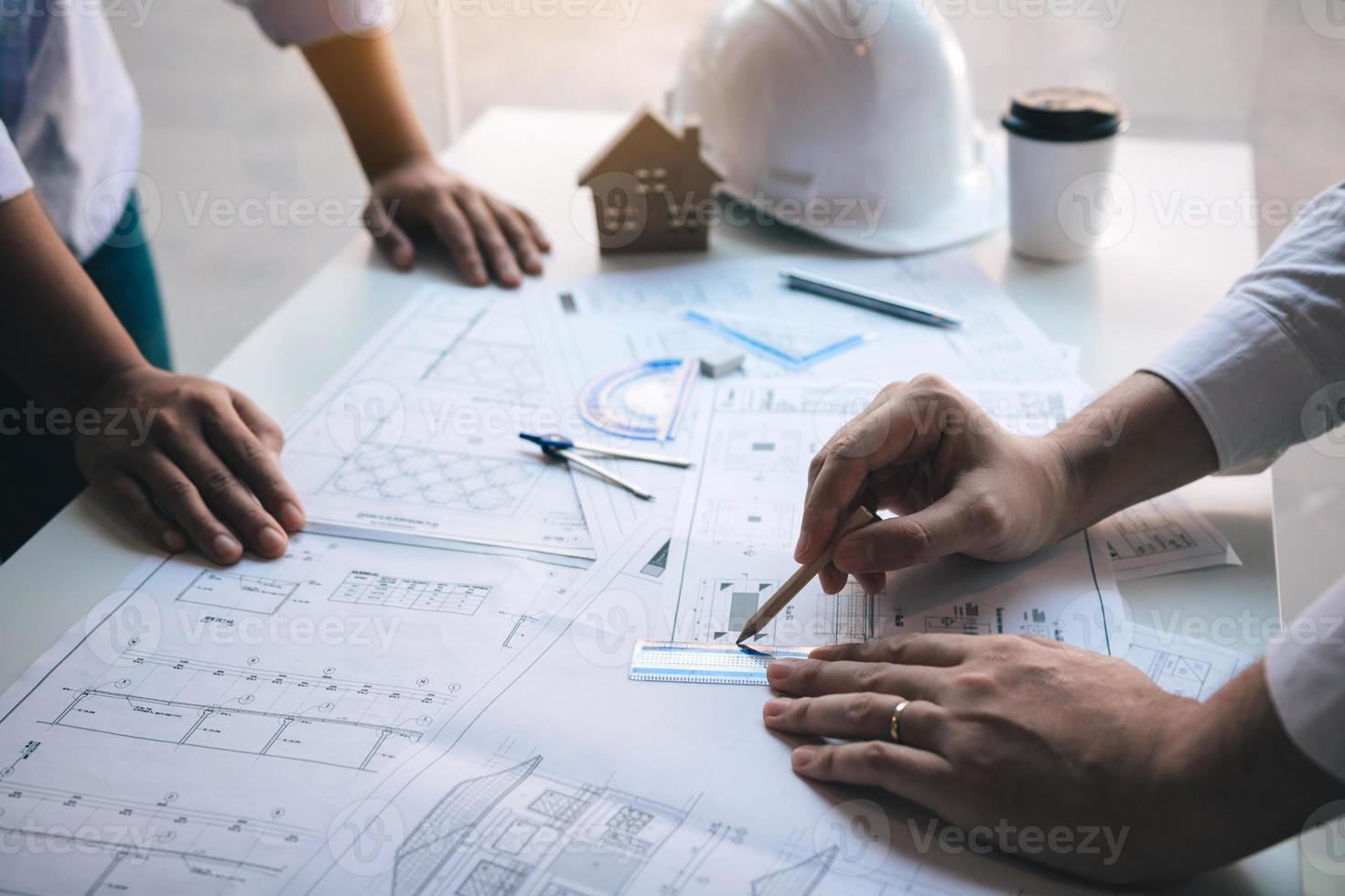 arquiteto trabalhando na planta discutindo novo projeto com colega no escritório. foto