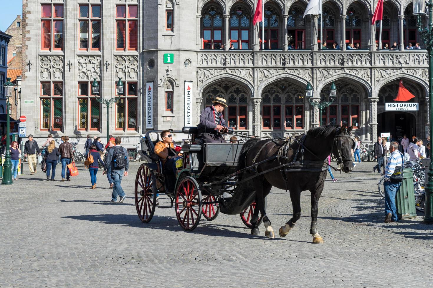 bruges, bélgica, 2015. cavalo e carruagem na praça do mercado bruges, flandres ocidental, na bélgica foto