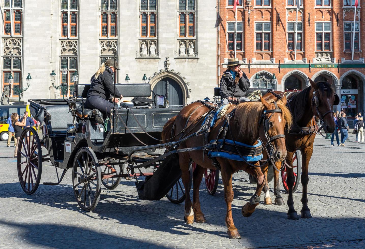 bruges, bélgica, 2015 cavalos e carruagens na praça do mercado bruges flandres ocidental na bélgica foto