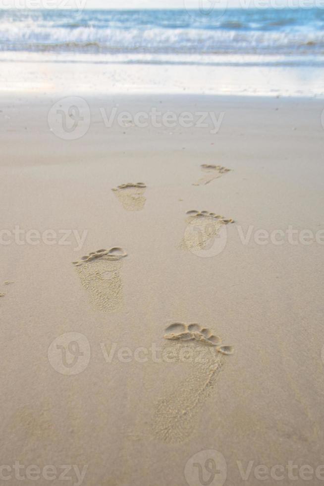 pegadas na praia de areia rayong na tailândia foto