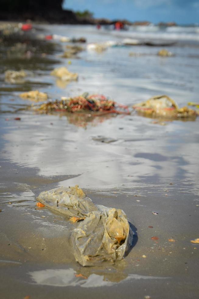 poluições e lixos na praia de pessoas foto