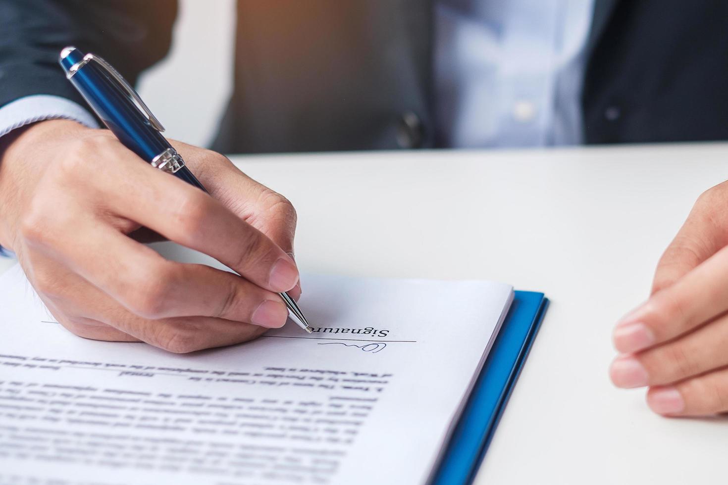 homem assinando documentos do contrato depois de ler, homem segurando caneta e aprova no relatório de negócios. acordo de contrato, lei e conceitos de negócio foto