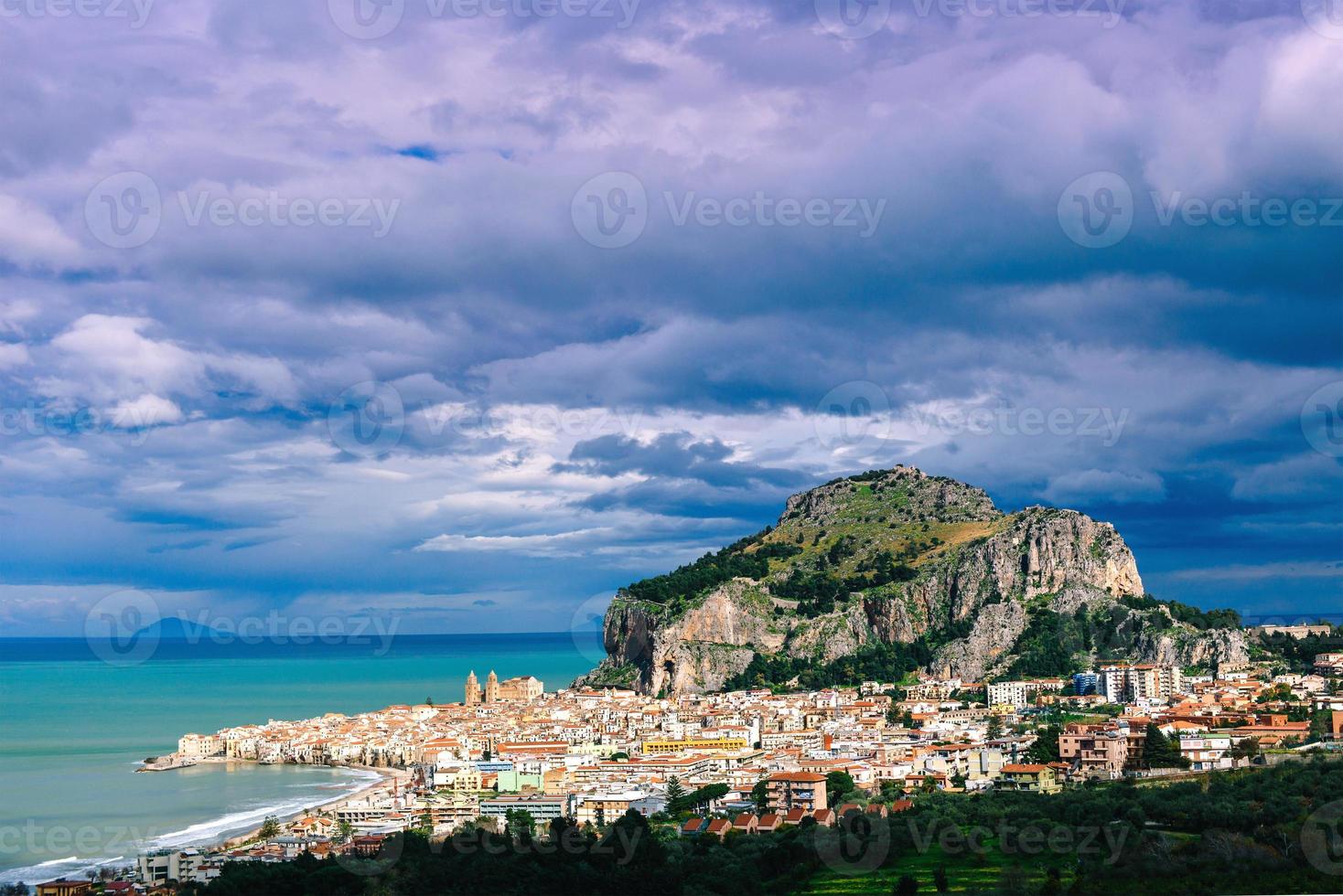 cidade velha à beira-mar, montanhas baixas ao fundo foto