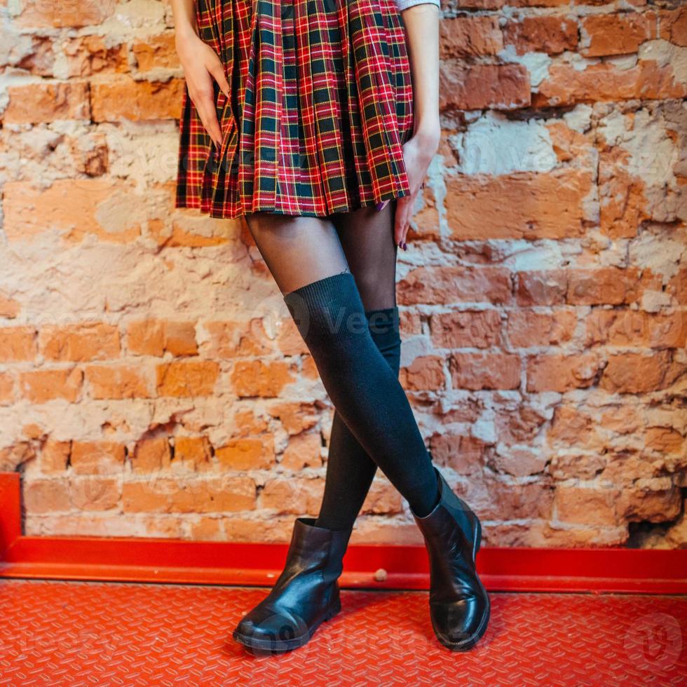 pernas sexy de uma garota de saia e botas pretas foto
