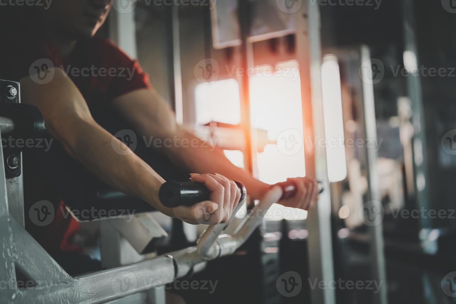 homem esporte usando exercícios de haltere no ginásio. fisiculturismo asiático para treinamento muscular. conceito de esporte foto