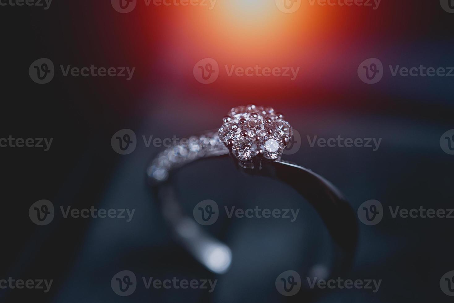 joias de luxo. anel de noivado de prata branco com diamantes closeup em fundo de vidro preto. foco seletivo. foto