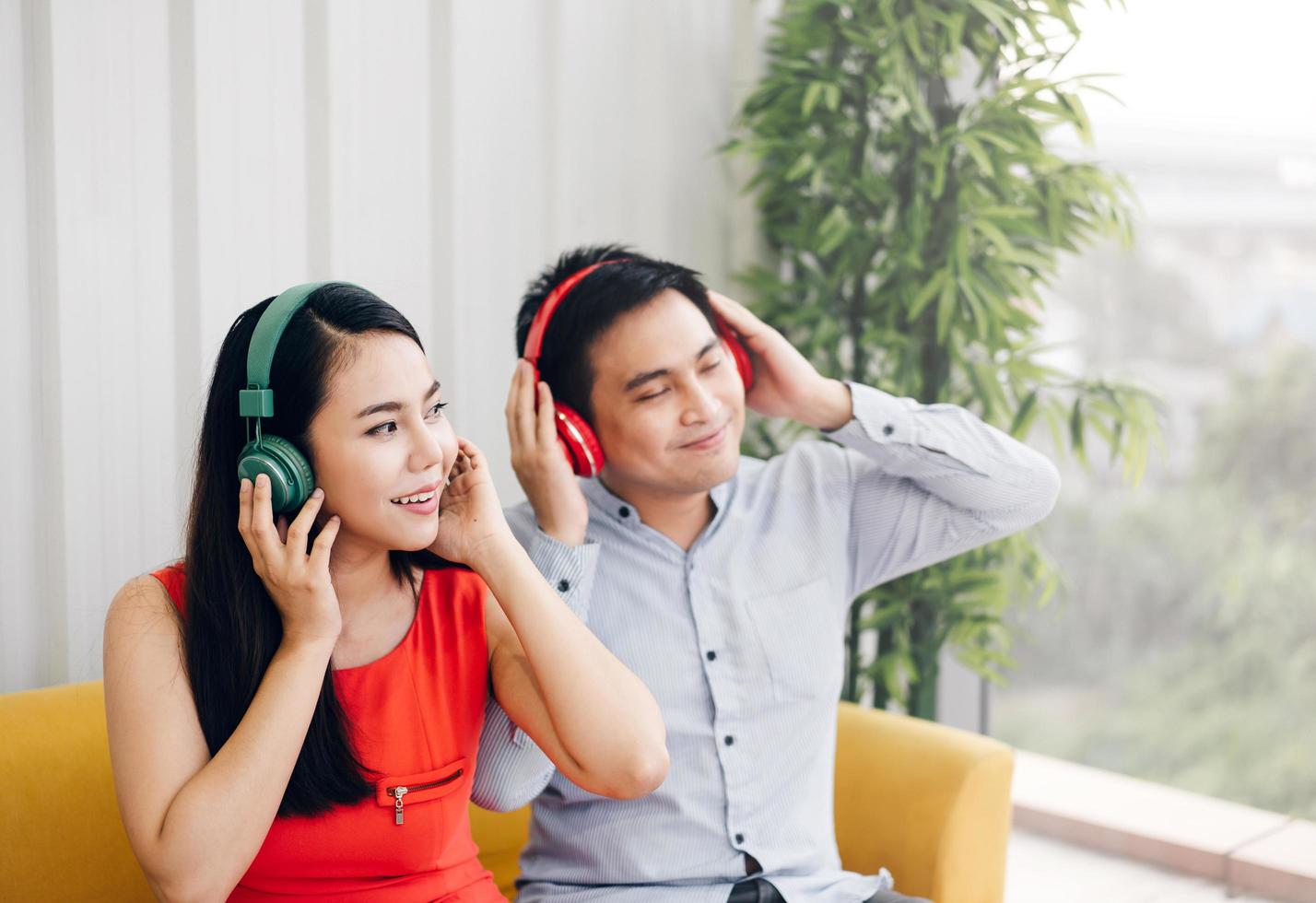 casal asiático adulto ouve música com fone de ouvido. foto