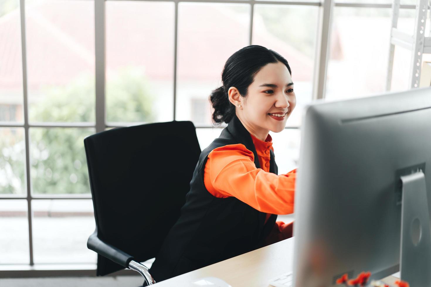 mulher asiática de negócios trabalha com sorriso feliz e concentração para o trabalho foto