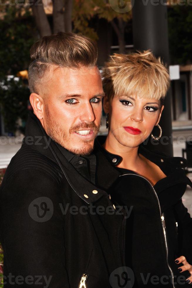 elegante jovem casal vestido de preto com penteado da moda. fotografia de moda urbana. imagem vertical. foto