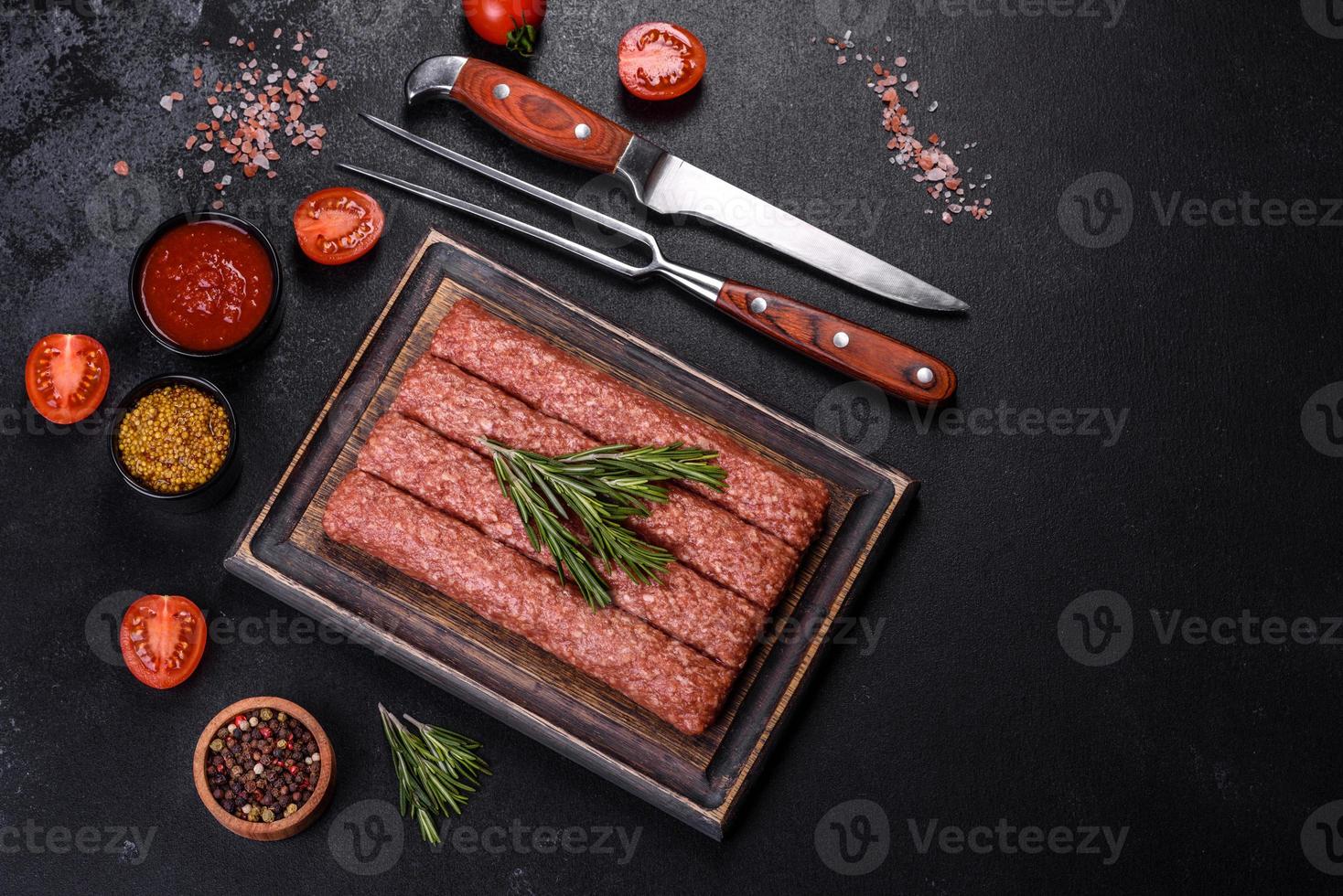 carne moída crua fresca para kebab grelhado com especiarias e ervas em um fundo escuro de concreto foto