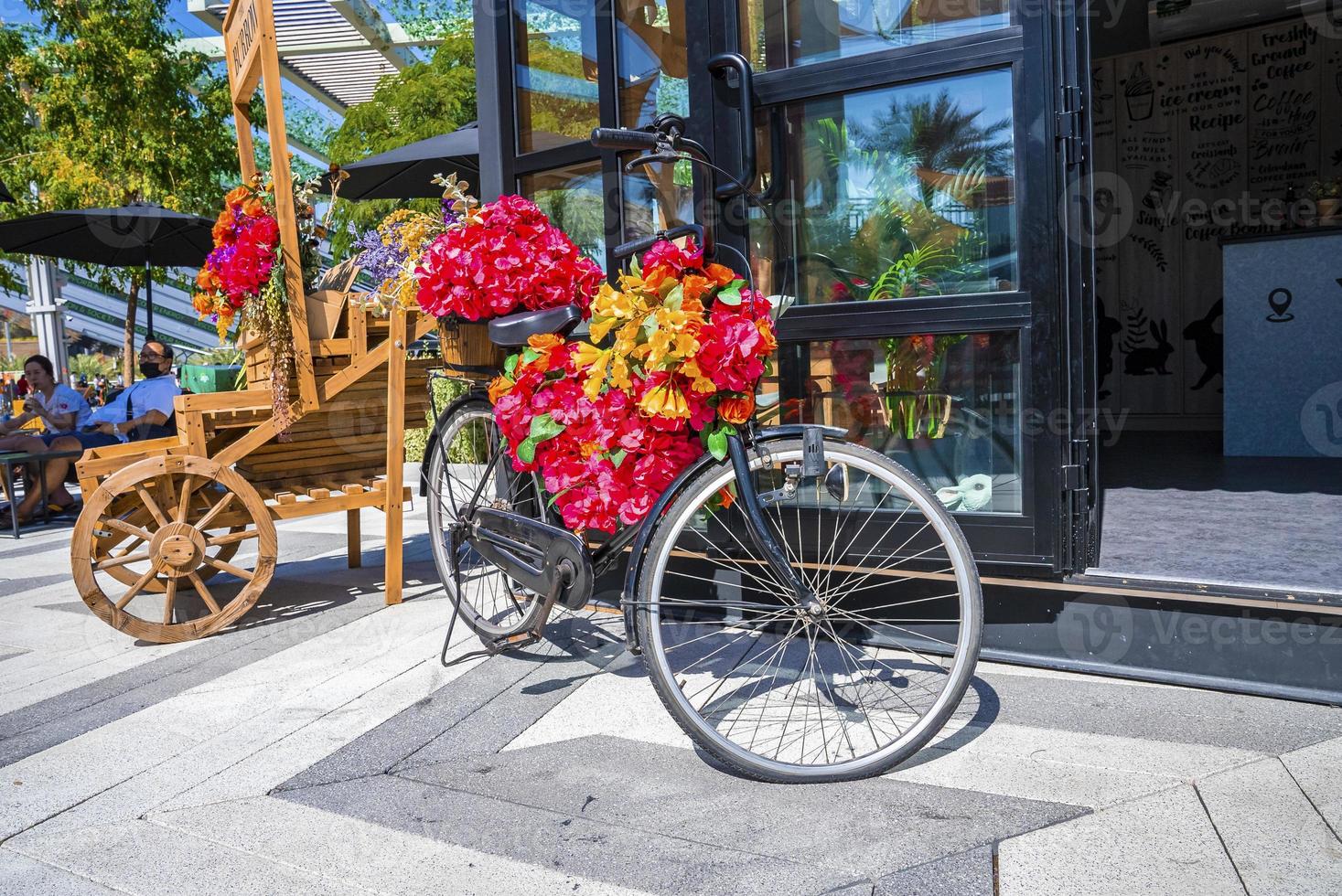 bicicleta com buquê de flores na frente da entrada do café foto