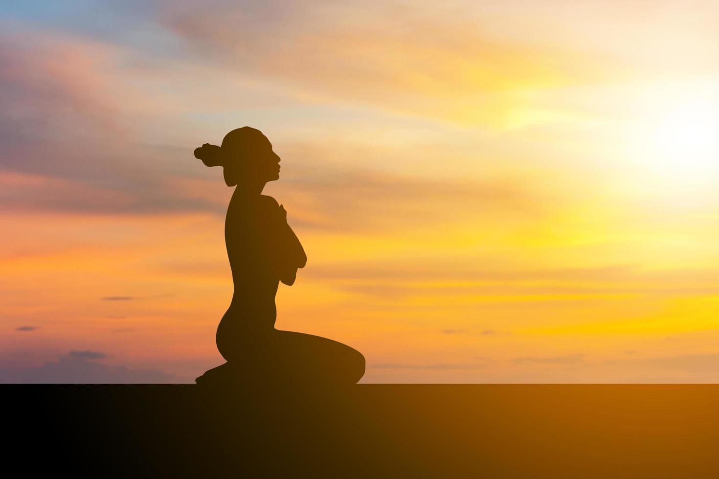 silhueta de jovem com traçado de recorte praticando ioga relaxante exercício ao pôr do sol foto