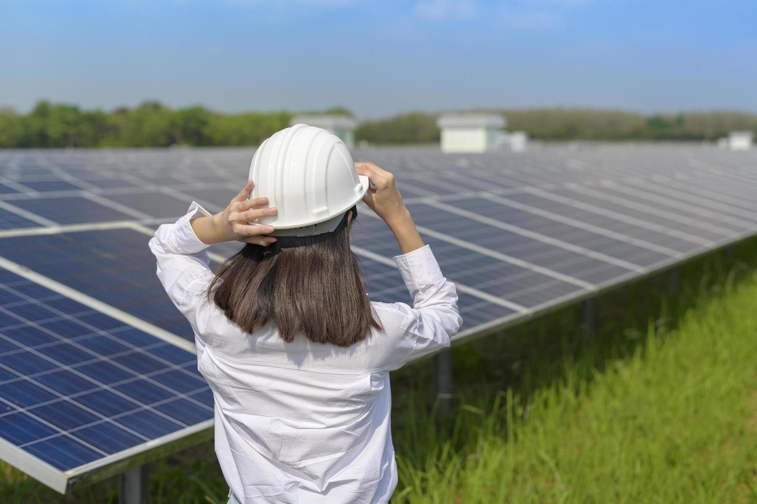 engenheira usando capacete em fazenda de células fotovoltaicas ou campo de painéis solares, energia ecológica e limpa. foto