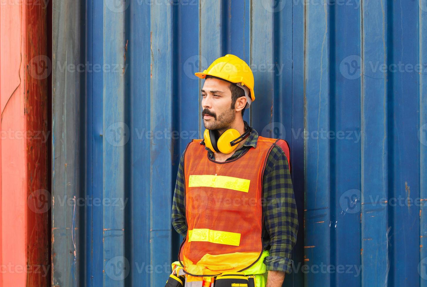 homem trabalhador em pé relaxe com uma pausa para fumaça de cigarro, trabalho faz uma pausa para cigarro na caixa do recipiente foto