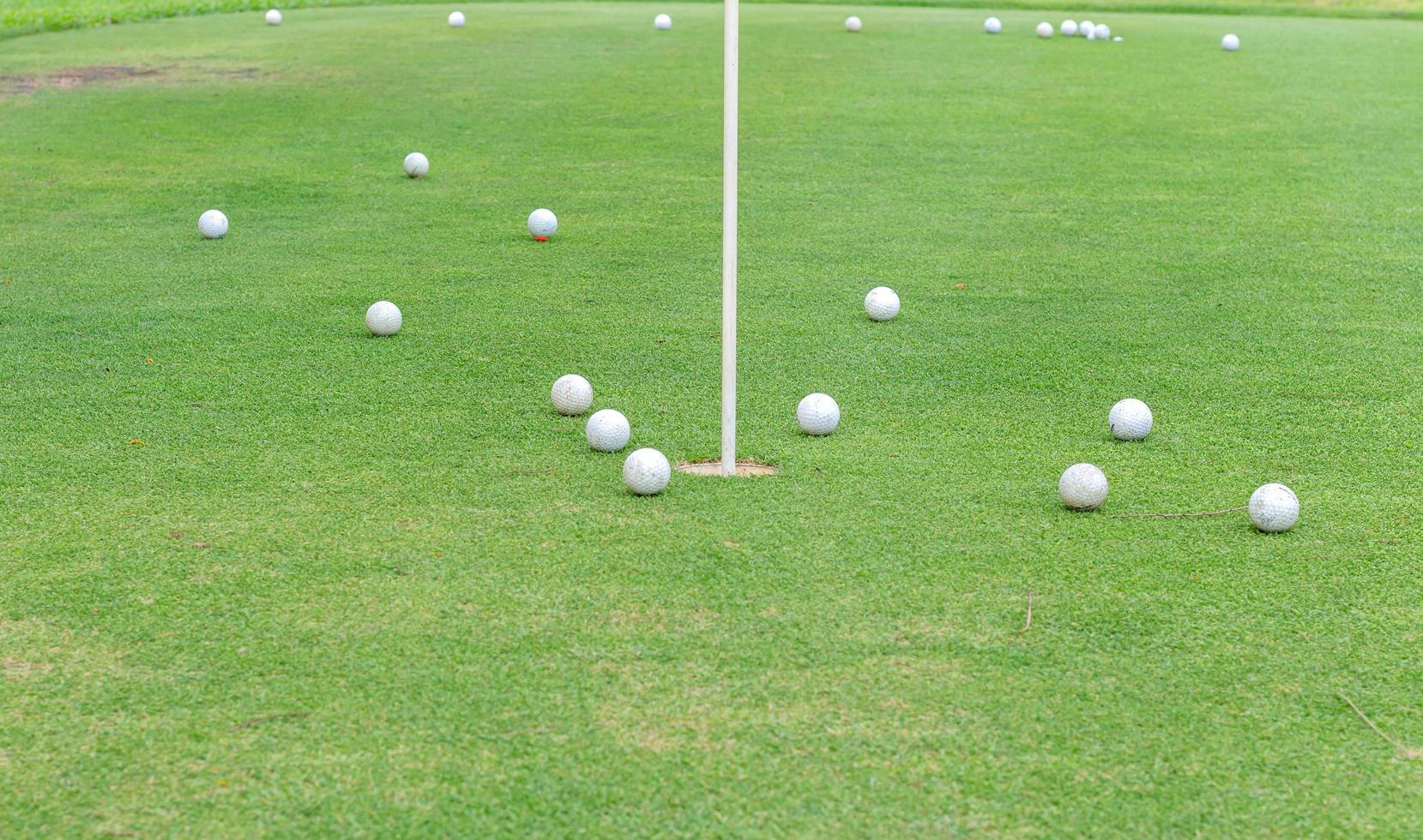 buracos de golfe e bolas de golfe na grama foto