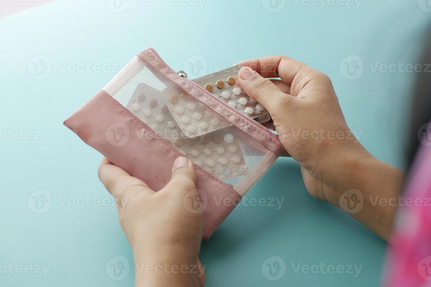 mão de mulheres segurando pílulas anticoncepcionais close-up foto