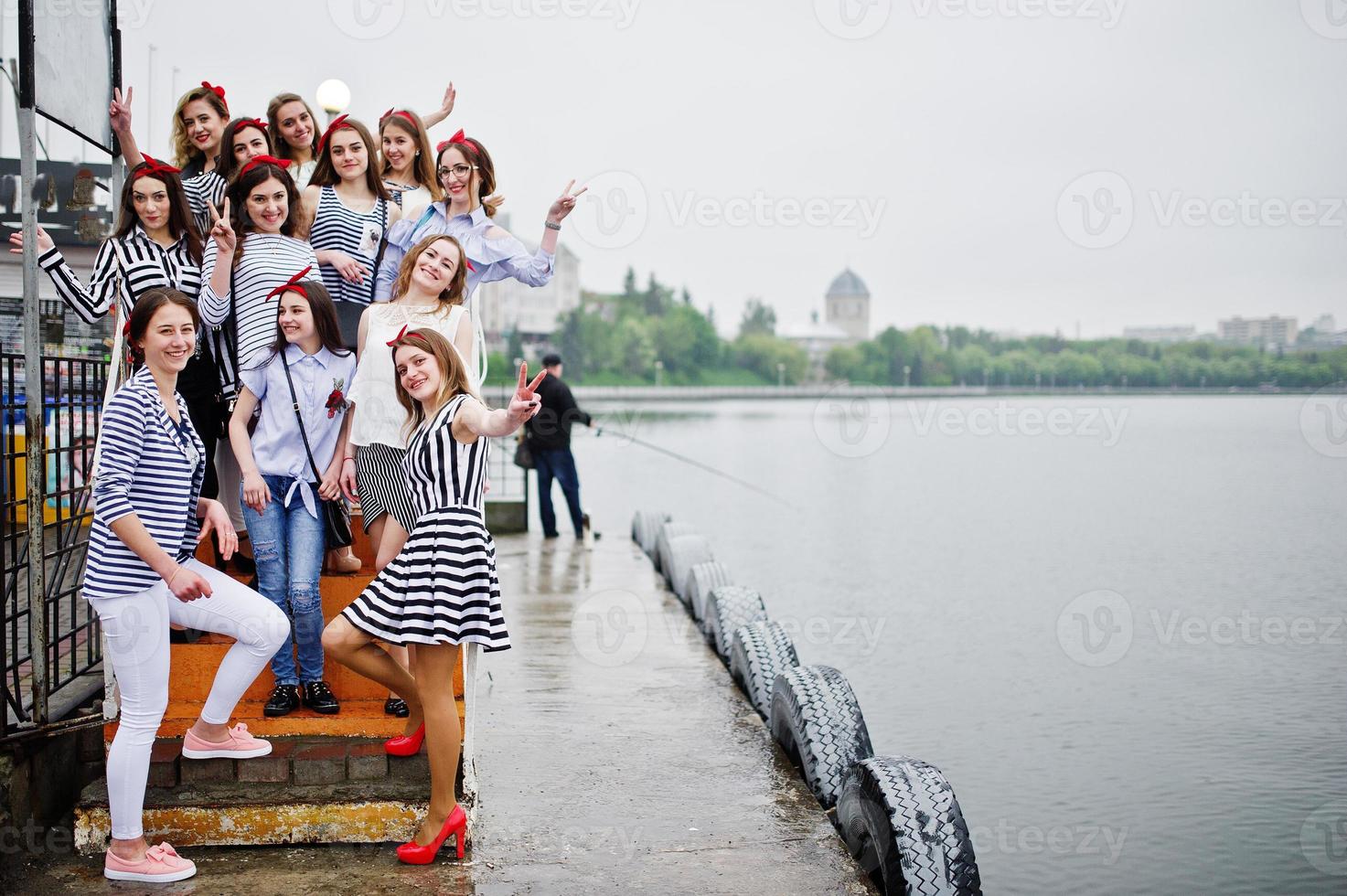 fabulosas damas de honra posando no cais ao lado do lago com sua noiva impecável. despedida de solteira. foto