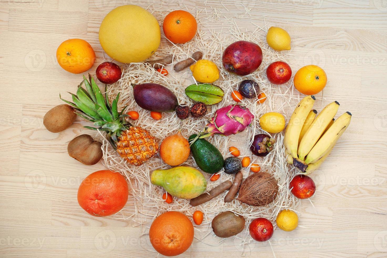 frutas exóticas em fundo de madeira. alimentação saudável dieta alimentar. pitaia, carambola, mamão, abacaxi, manga, maracujá, tamarindo e outros. foto