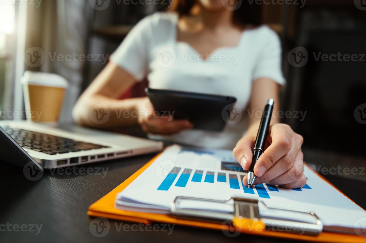 mão de mulher de negócios trabalhando com computador portátil, tablet e telefone inteligente no escritório com mídia de marketing digital foto