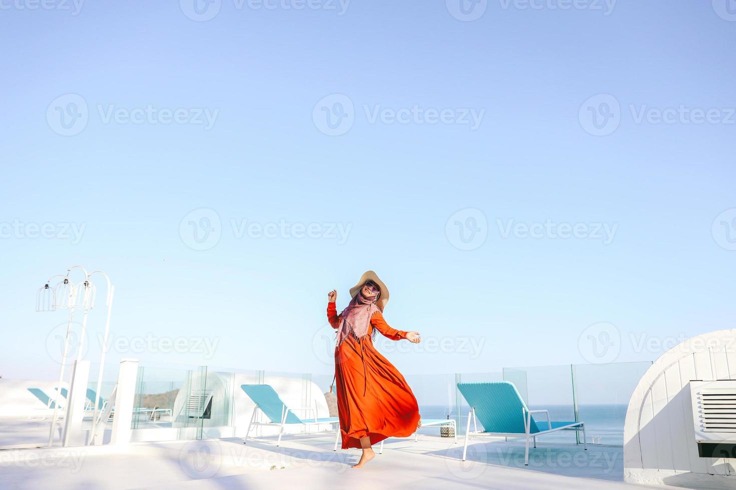 turista de mulheres felizes em vestido vermelho e chapéu de verão dançando e se divertindo nas férias foto